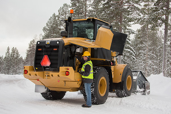 construction worker with CAT compact construction equipment in the winter