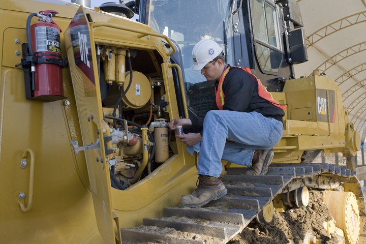 Technician working on a piece of Caterpillar equipment